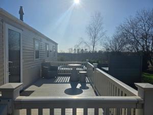 a wooden deck with a table on a house at Dixons Den Hot Tub in Swarland