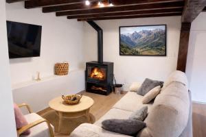 a living room with a couch and a fireplace at El Refugio de Redo - balcón a los Picos de Europa in Camaleño