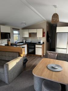 a living room and kitchen with a couch and a table at Dixons Den Hot Tub in Swarland