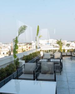 eine Terrasse mit Tischen und Stühlen auf einem Dach in der Unterkunft Hotel AM PM in Bhubaneshwar