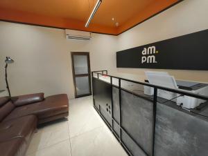 ein Büro mit einer Couch und einem Schild an der Wand in der Unterkunft Hotel AM PM in Bhubaneshwar