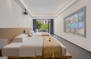 two beds in a hotel room with a large screen at Jiheshan residential accommodation Yulong River Yangshuo in Yangshuo