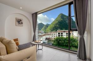 a living room with a large window with a view at Jiheshan residential accommodation Yulong River Yangshuo in Yangshuo