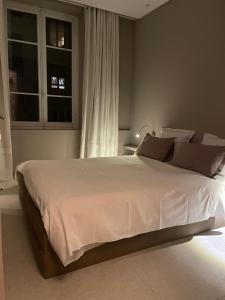 a bedroom with a large white bed with a window at Chambre Gounod in Nice