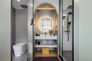 a bathroom with a toilet and a mirror at Jiheshan residential accommodation Yulong River Yangshuo in Yangshuo +28 photos