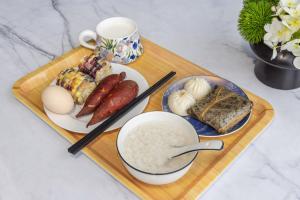 a tray of food with rice and meats and a cup at Jiheshan residential accommodation Yulong River Yangshuo in Yangshuo