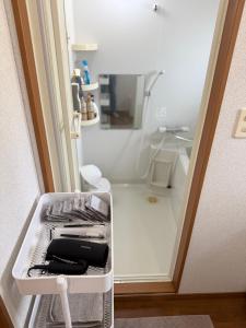 a small kitchen with a sink and a refrigerator at 宿Oshikiri 04 in Shibushi