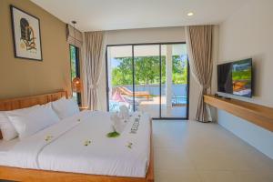 a bedroom with a large bed and a tv at FarmSaijai Kohphangan in Hinkong