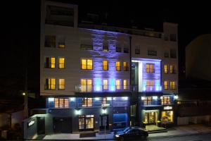 un edificio con luces azules por la noche en Hotel Sterling Garni en Belgrado