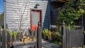 a red door on a house with a fence at Nouvelle Studio in Epsom