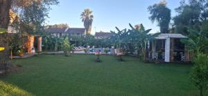 a backyard with a grass yard with a house at Amelia's Garden ΙΙ in Kavos
