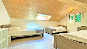 a bedroom with two beds and a ceiling with a window at Chalet - Magnifique chalet d'architecte 10 pers MAE-2774 in Les Prés +10 photos