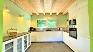 a large kitchen with white cabinets and a window at Chalet - Magnifique chalet d'architecte 10 pers MAE-2774 in Les Prés