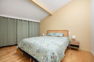 a bedroom with a bed with a blue comforter at Beautiful House avec AC climatisation - terrasse privée - Côté pavé centre-ville Toulouse in Toulouse