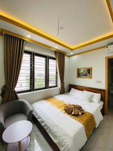a bedroom with a large bed and a chair at Hotel 24h in Hai Phong +7 photos