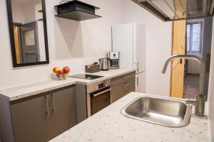 a kitchen with a sink and a counter top at Apartamenty Centrum Biskupiec in Biskupiec +21 photos