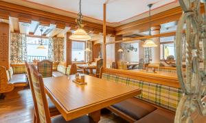a dining room with a wooden table and chairs at Hotel Wechselberger by Alpeffect Hotels in Saalbach-Hinterglemm