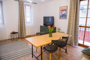 a dining room with a wooden table and chairs at Apartamenty Centrum Biskupiec in Biskupiec