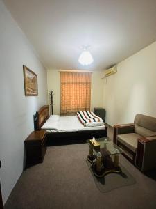 a bedroom with a bed and a couch and a window at Afghania Guest House in Kabul