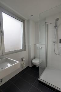 a bathroom with a shower and a sink and a toilet at Palazzo Hotel in Mannheim +24 photos