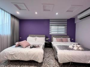 two beds in a room with purple walls at Aren Inn in Zhushan