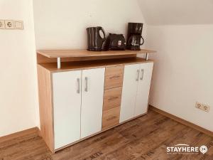 a room with a shelf and a white cabinet at StayHere24 Maisonette-Wohnung mit großem Garten in Leipzig