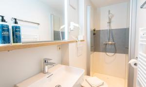 a bathroom with a sink and a shower at Hotel Wechselberger by Alpeffect Hotels in Saalbach-Hinterglemm +36 photos