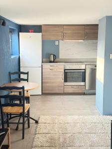a kitchen with a table and a white refrigerator at Haven Home in Stavanger