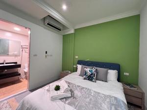 a bedroom with a bed and a green wall at Aren Inn in Zhushan
