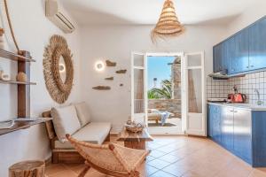 a living room with a couch and a kitchen at Syros Apartments Suites Chryssonisos Kini in Kini
