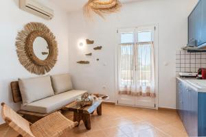 a living room with a couch and a table at Syros Apartments Suites Chryssonisos Kini in Kini