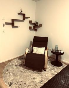 a living room with a chair and a table at Comfort Rooms mit Whirlpoolzugang in Romanshorn