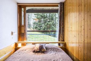 a bedroom with a bed in front of a window at Résidence Nova 1 - Appartement 2 pièces 6 personnes proche des pistes MAE-7984 in Arc 1800