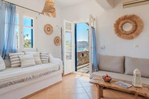 a living room with a couch and a table at Syros Apartments Suites Chryssonisos Kini in Kini