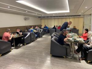 a group of people sitting at tables in a restaurant at Hotel Gold The Royal A Luxurious Stay- Near New Delhi Railway Station & Connaught Place in New Delhi
