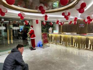 a man sitting in front of a store with a santa at Hotel Gold The Royal A Luxurious Stay- Near New Delhi Railway Station & Connaught Place in New Delhi +147 photos