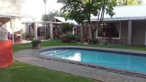 a swimming pool in a yard next to a house at Red olive guesthouse in Parys