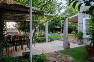 a patio with chairs and a table and a pool at Red olive guesthouse in Parys
