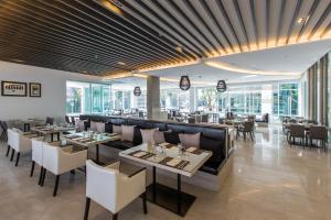 a restaurant with tables and chairs and a bar at Kantary 304 Hotel Prachinburi in Si Maha Phot
