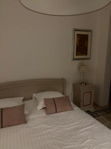 a bedroom with a white bed with two pillows at Confort Taillans in Donzère