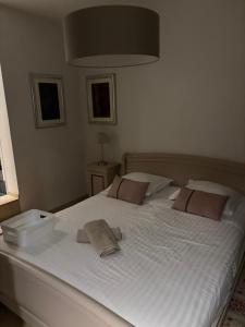 a large white bed with two towels on it at Confort Taillans in Donzère