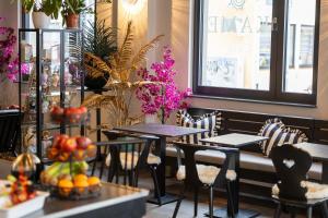 a restaurant with tables and chairs with fruits and flowers at Palazzo Hotel in Mannheim