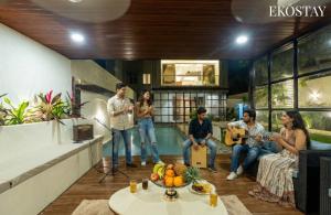 a group of people in a living room playing music at EKOSTAY - Casa Enzo 7BHK -Theatre Room Private Swimming Pool and Indoor Games in Lonavala