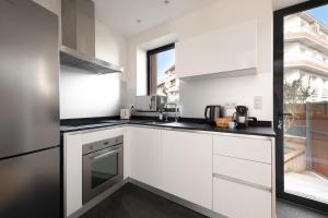 a kitchen with white cabinets and a window at Beautiful House avec AC climatisation - terrasse privée - Côté pavé centre-ville Toulouse in Toulouse +27 photos