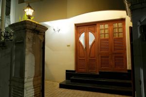 a door in a hallway with stairs and a lamp at Spicened inn in Cochin +6 photos