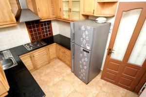 a kitchen with a stainless steel refrigerator and wooden cabinets at Spicened inn in Cochin