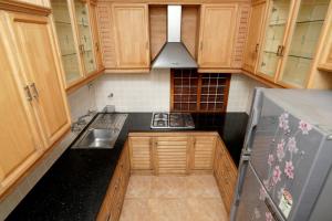 a small kitchen with wooden cabinets and a sink at Spicened inn in Cochin