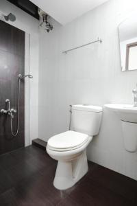 a white bathroom with a toilet and a sink at Spicened inn in Cochin
