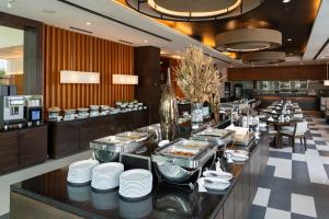 a restaurant with white plates on a counter at Kantary Hotel Ayutthaya in Phra Nakhon Si Ayutthaya +52 photos