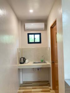 a small kitchen with a sink and a window at Simon Guest House in San Juan